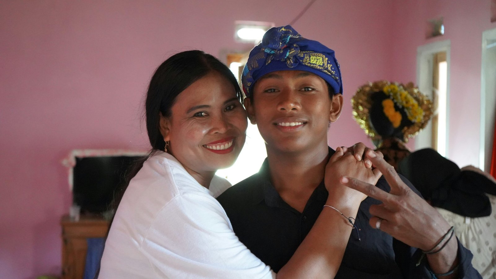 A man holding a woman in a pink room