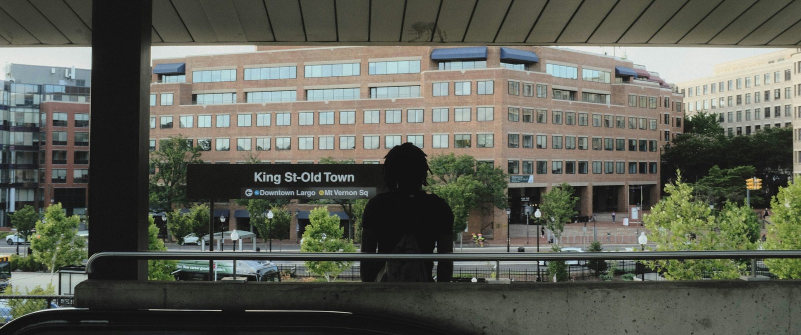 A person sitting on a bench looking out a window