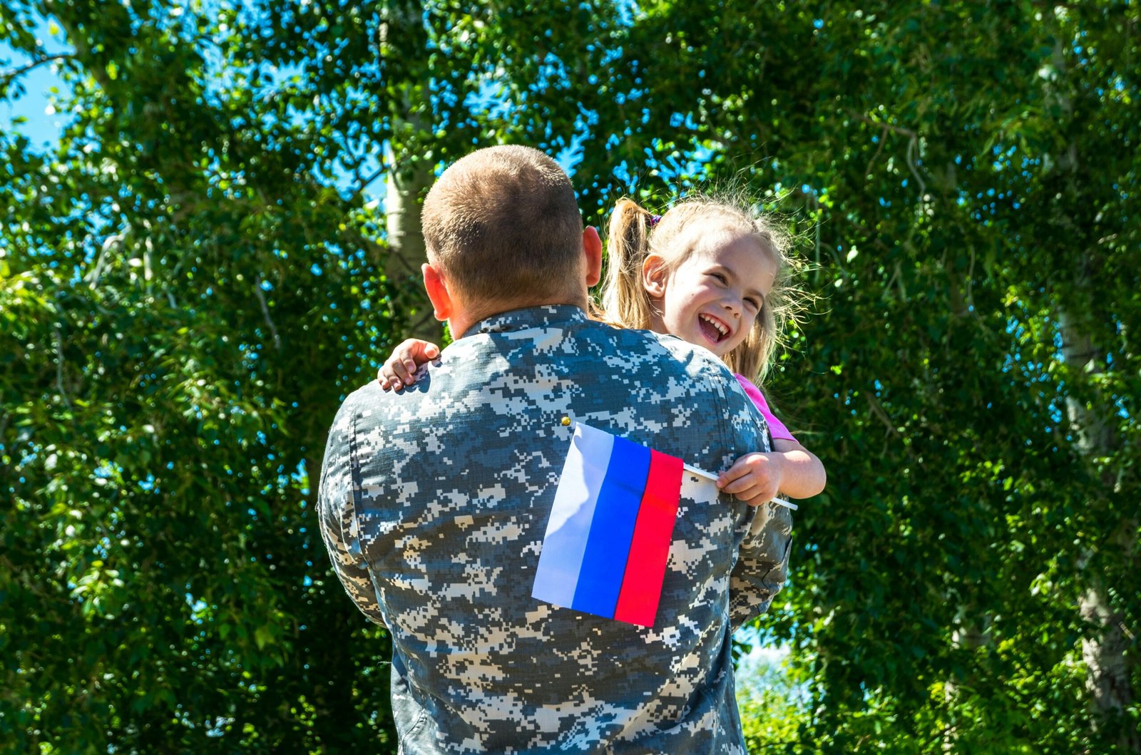 A soldier holding a little girl in his arms