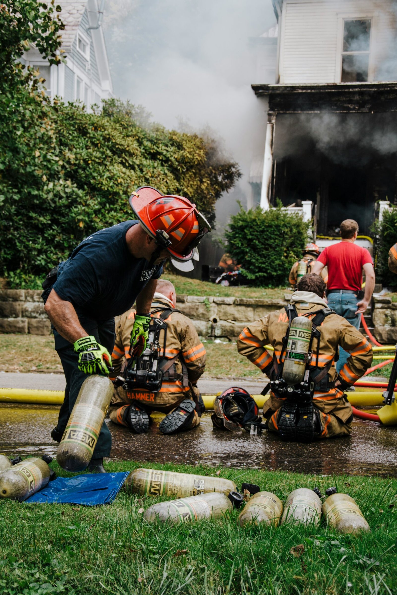 a group of firemen standing around a fire hydrant