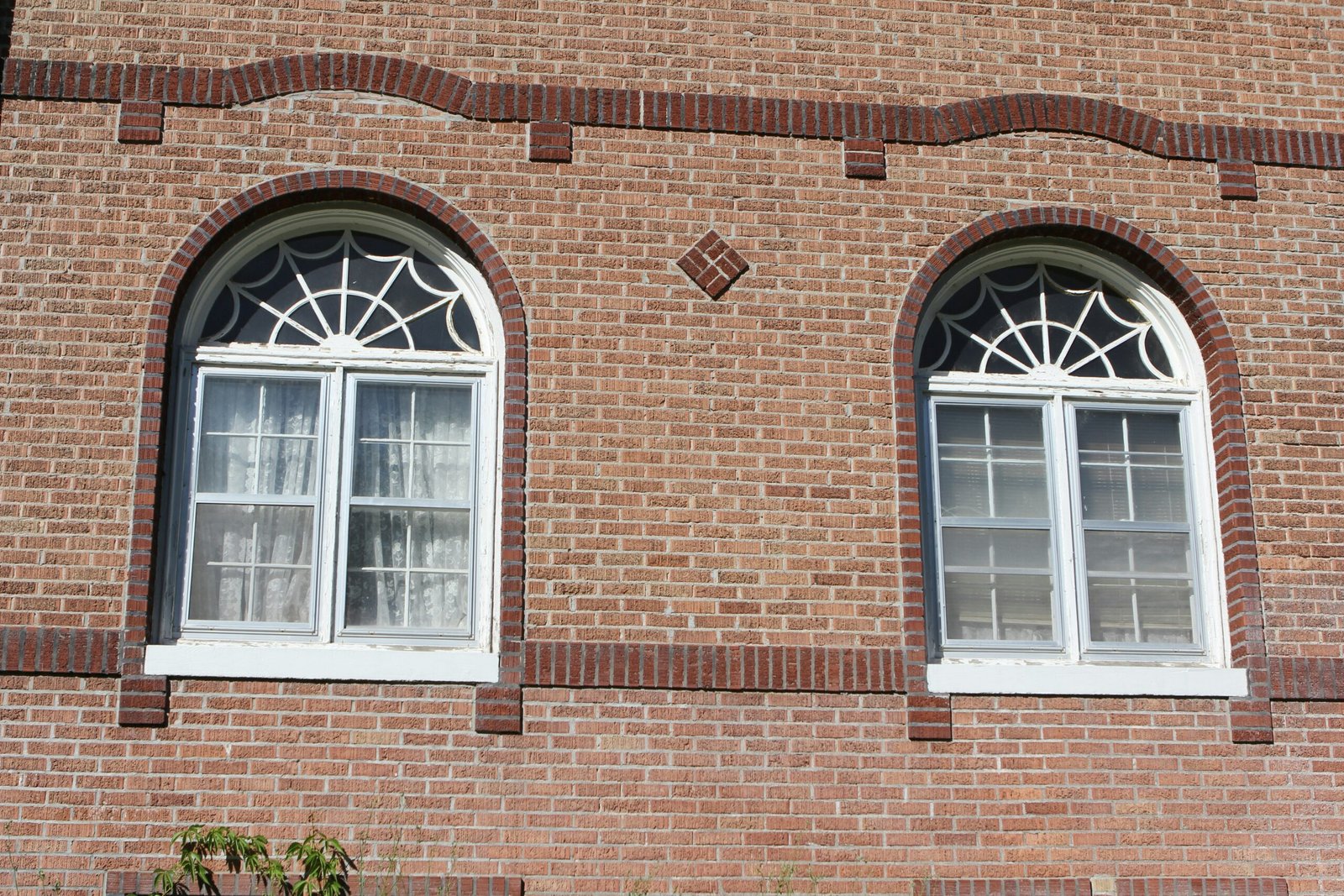 a red brick building with two white windows