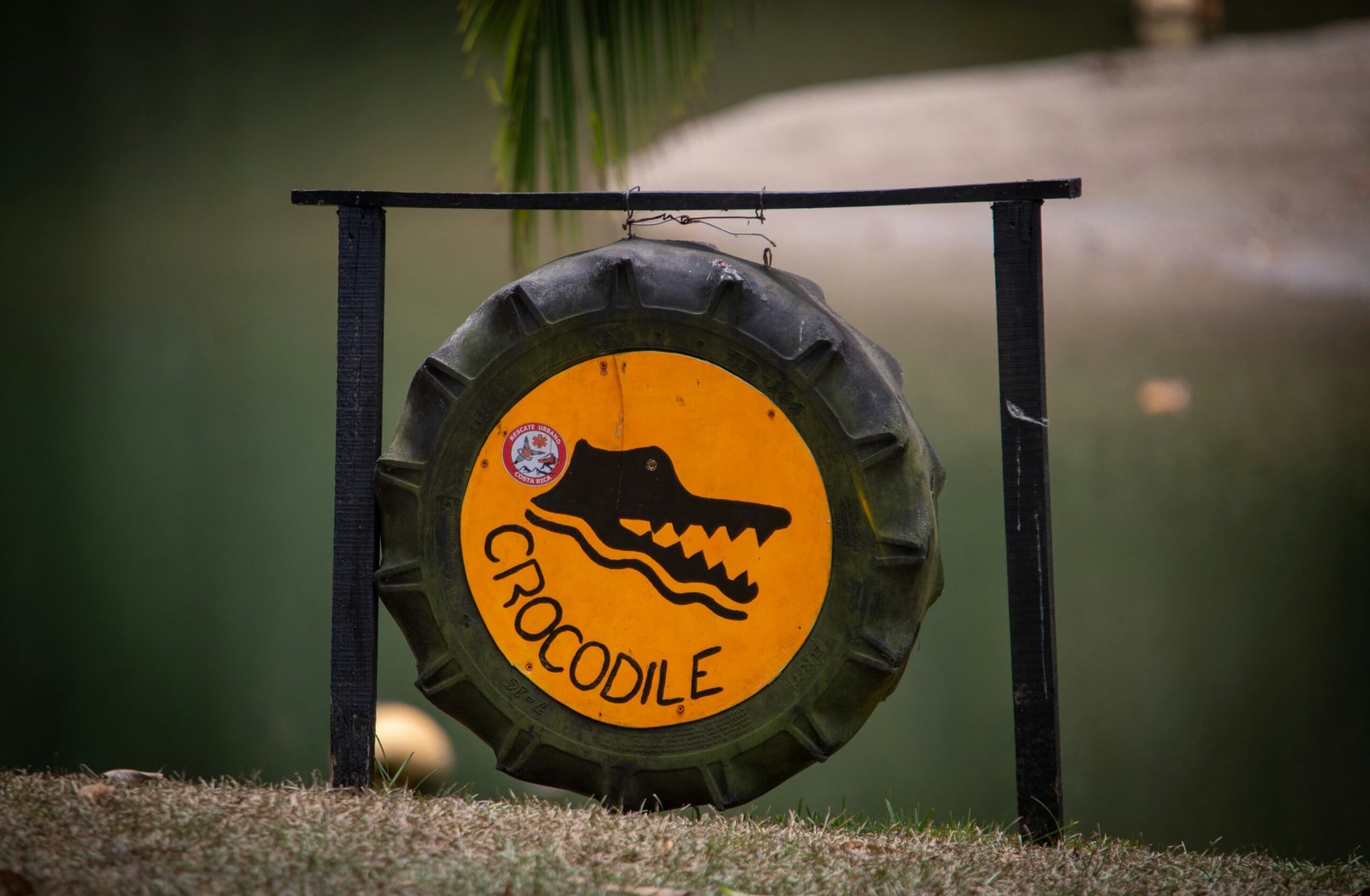 a yellow and black sign sitting on top of a grass covered field